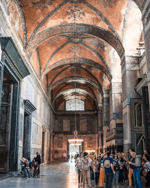 Anonymous tourists admiring interior of ancient church