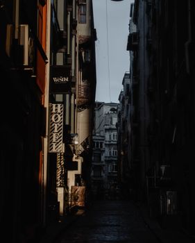 Narrow empty road going between old residential buildings in city district at dawn