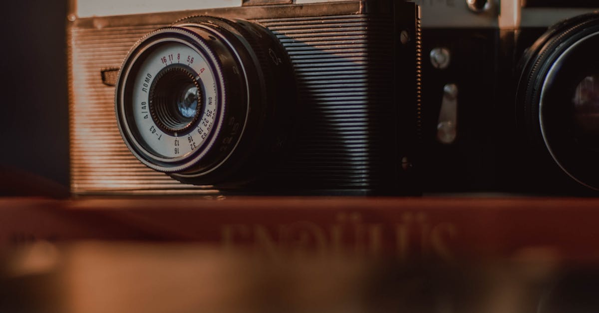 Shabby vintage film photo cameras with retro old fashioned lens and weathered body placed on wooden table with reflection
