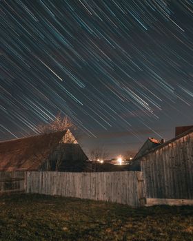 晴朗的夜晚，星星在乡村的房屋和栅栏间穿行