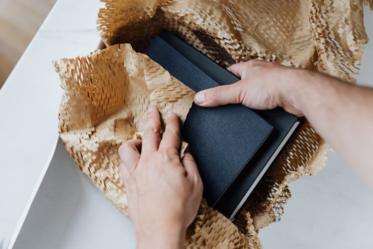 Anonymous Man Preparing Notebooks For Shipment