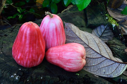 绿叶背景的天然原木上，展示着充满活力的玫瑰苹果，象征着新鲜和自然