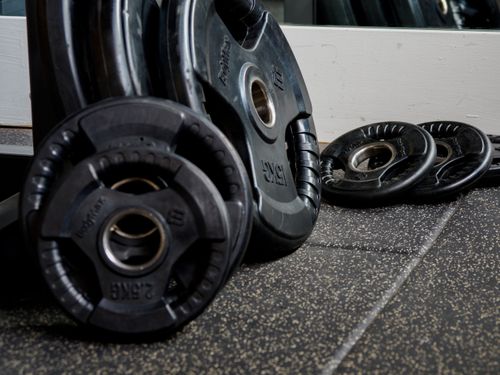 Free Detailed image of black weight plates stacked in a gym setting, perfect for fitness and workout themes. Stock Photo