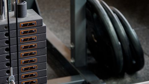 Detailed view of a gym machine's weight stack and weight plates, ideal for fitness-themed visuals.