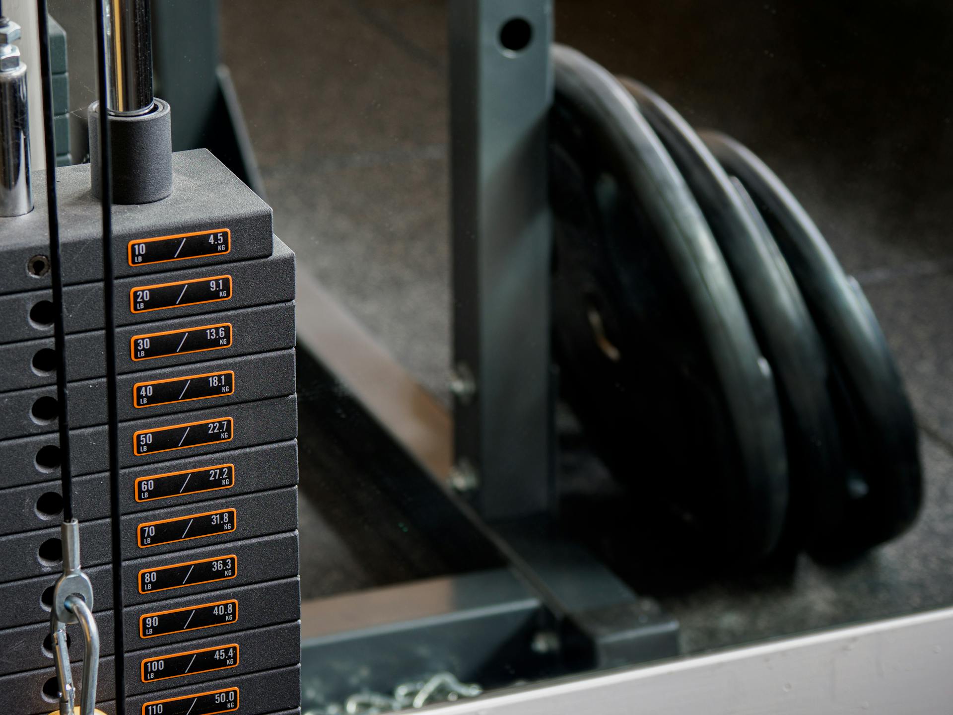 Detailed view of a gym machine's weight stack and weight plates, ideal for fitness-themed visuals.