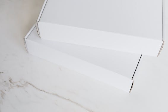 Set of white carton packages on marble surface
