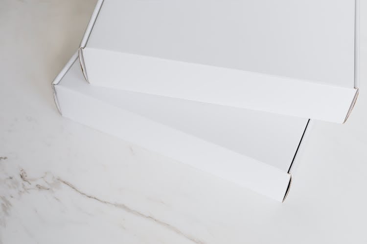 Set Of White Carton Packages On Marble Surface