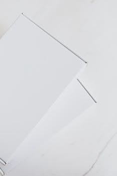 Simple white boxes on marble surface with negative space, perfect for branding.