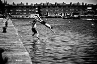 Boy and Girl Jumping in Body of Water
