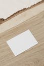 Empty white business card on wooden desk