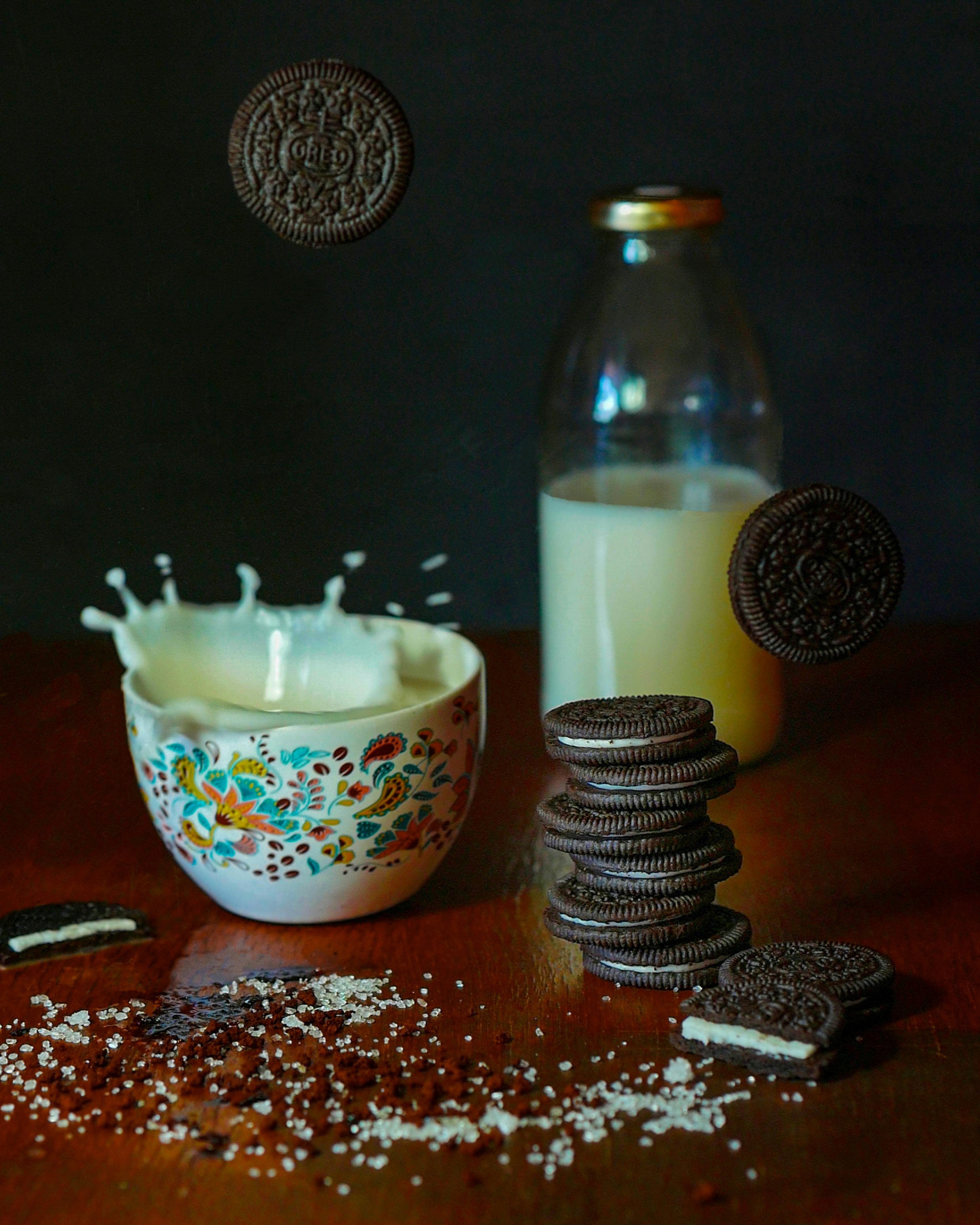 chocolate cookies falling into bowl with milk