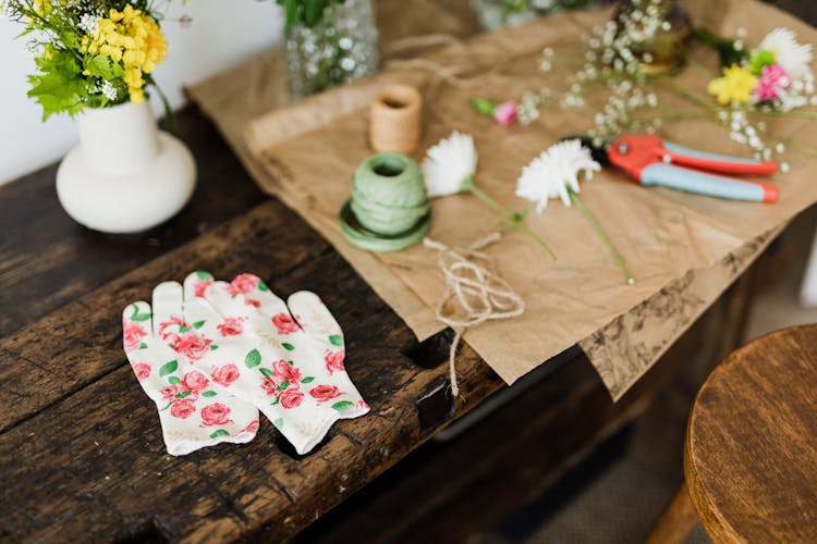 Pair Of Floral Gloves And Florists Working Tools On Bench