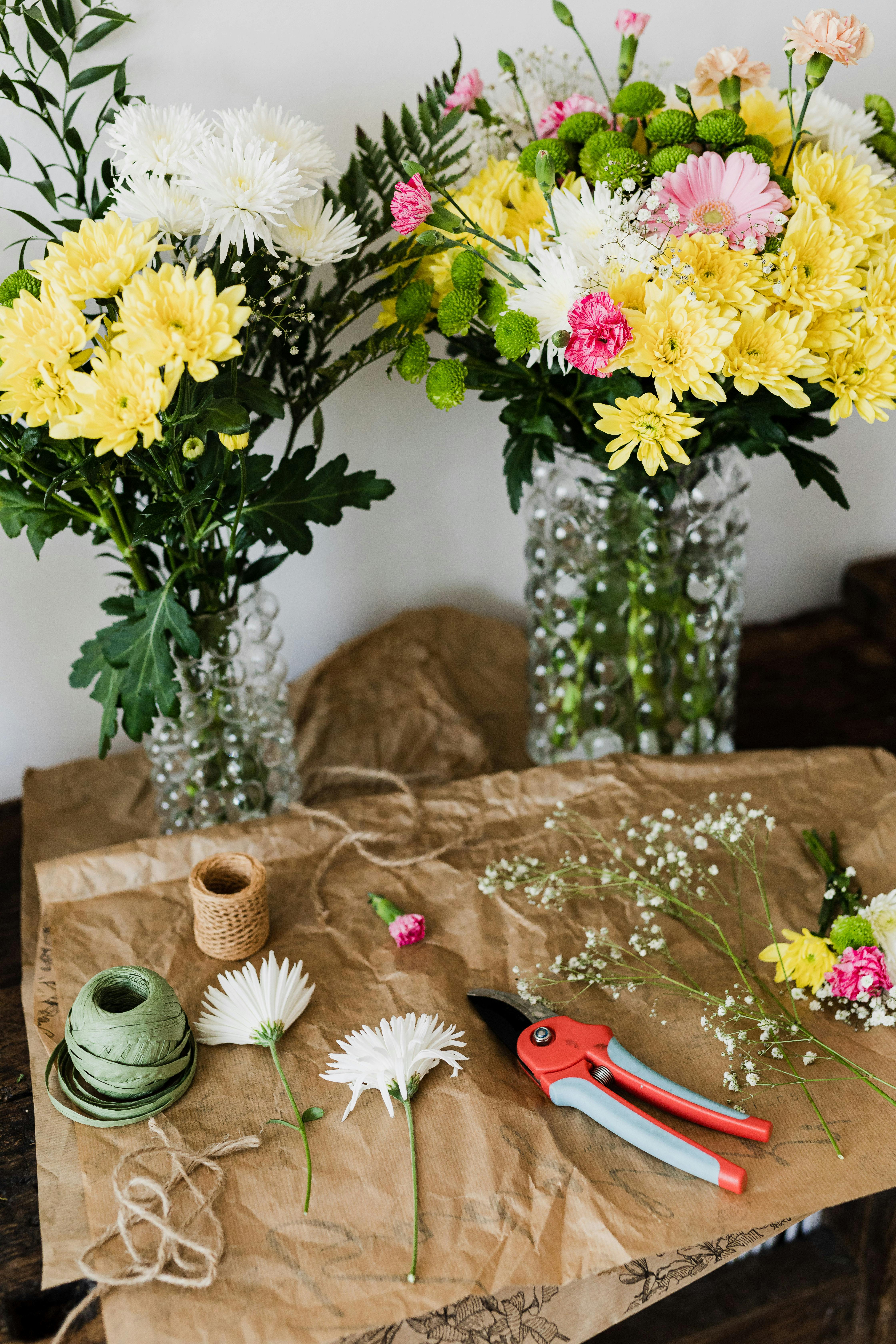 pruner and twine rolls on table with flower bouquets