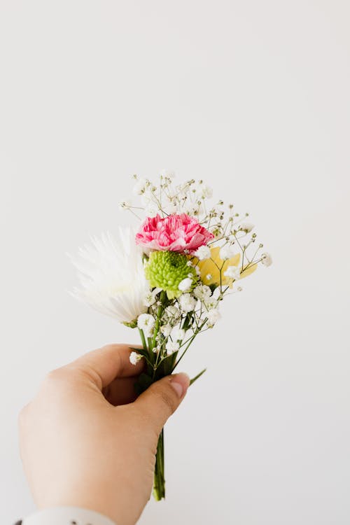 Crop woman with small bouquet of flowers