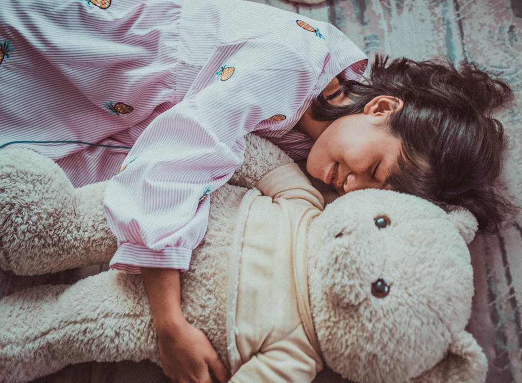 Free Happy ethnic teenager hugging toy Stock Photo