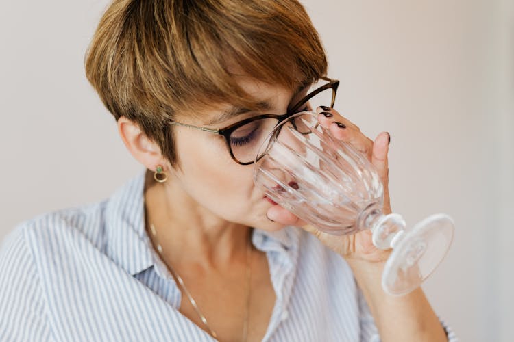 Woman With Short Hair In Glasses Drinking Water