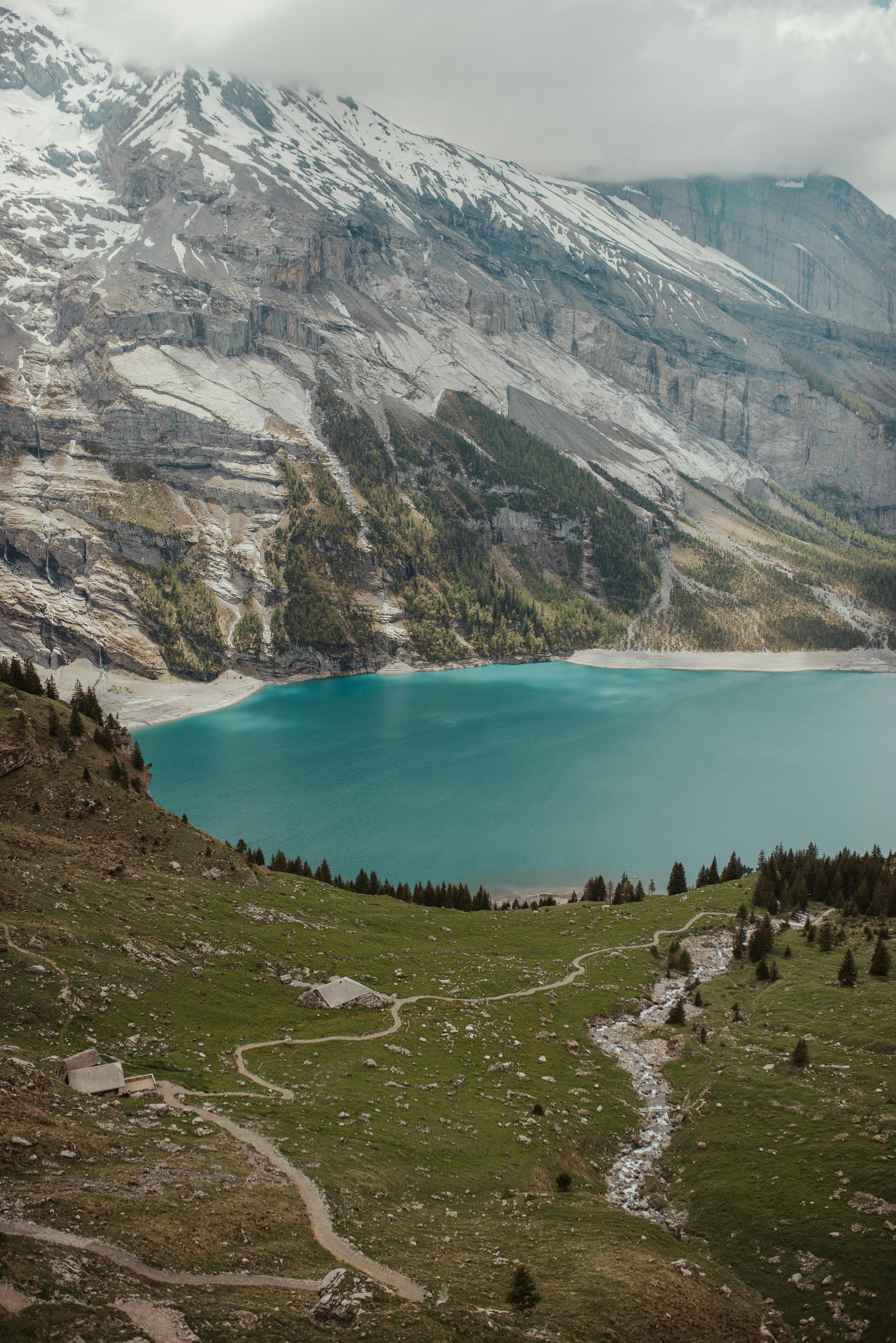 Prescription Goggle Inserts - Grassy slope with path located near peaceful lake and snowy mountains on overcast day in highlands