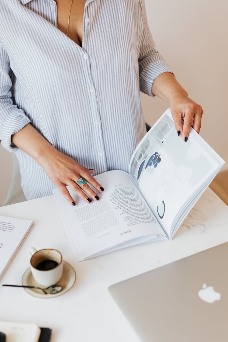 Crop Woman Reading Magazine And Drinking Hot Coffee