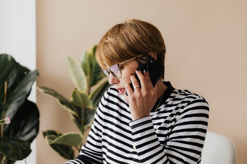 Free Serious businesswoman having phone conversation in light workplace Stock Photo