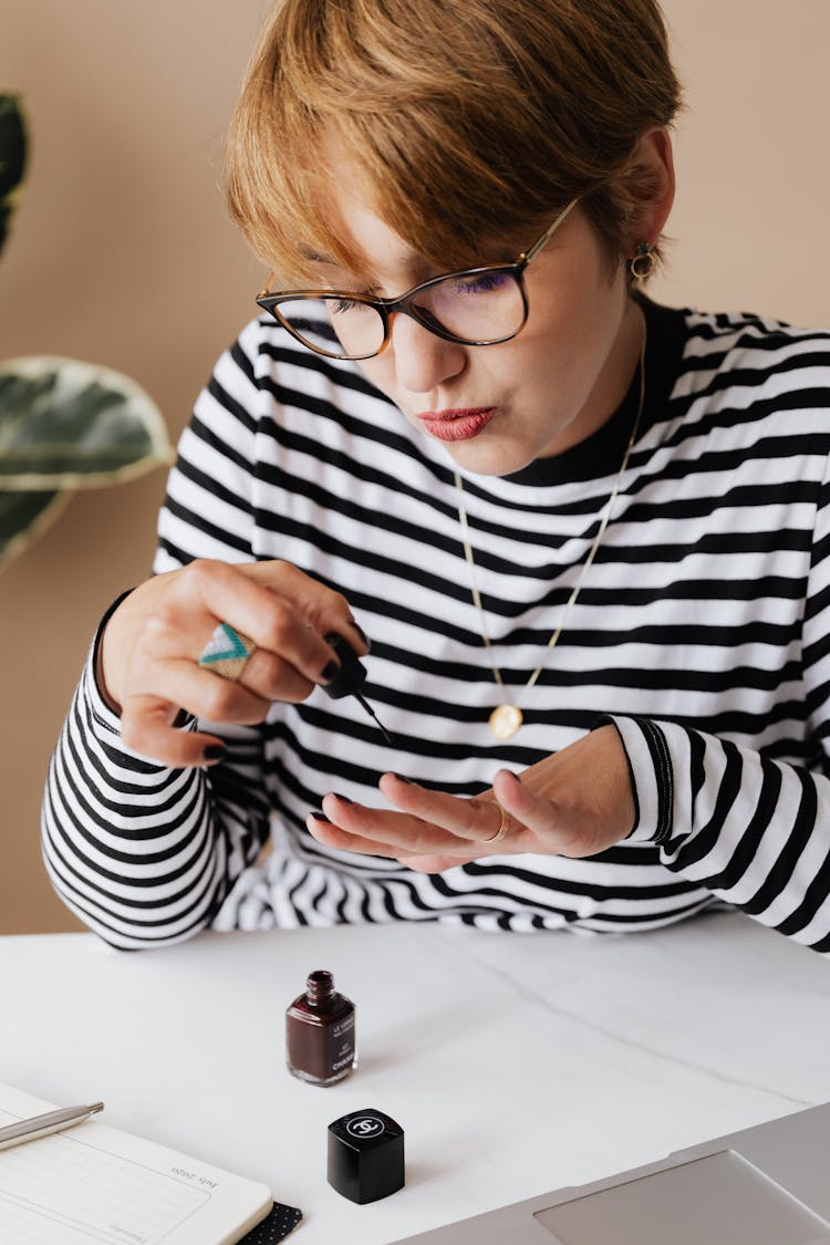 Focused Woman Doing Manicure At Home