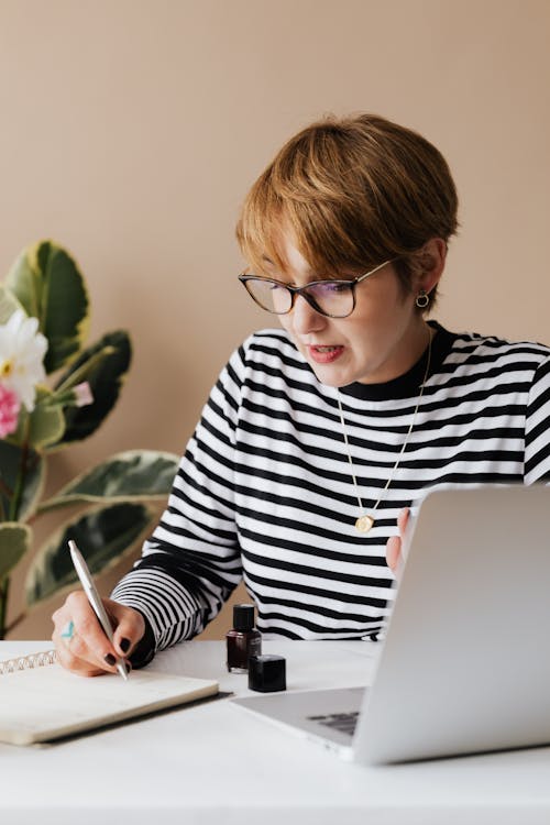 Focused woman writing notes in notebook