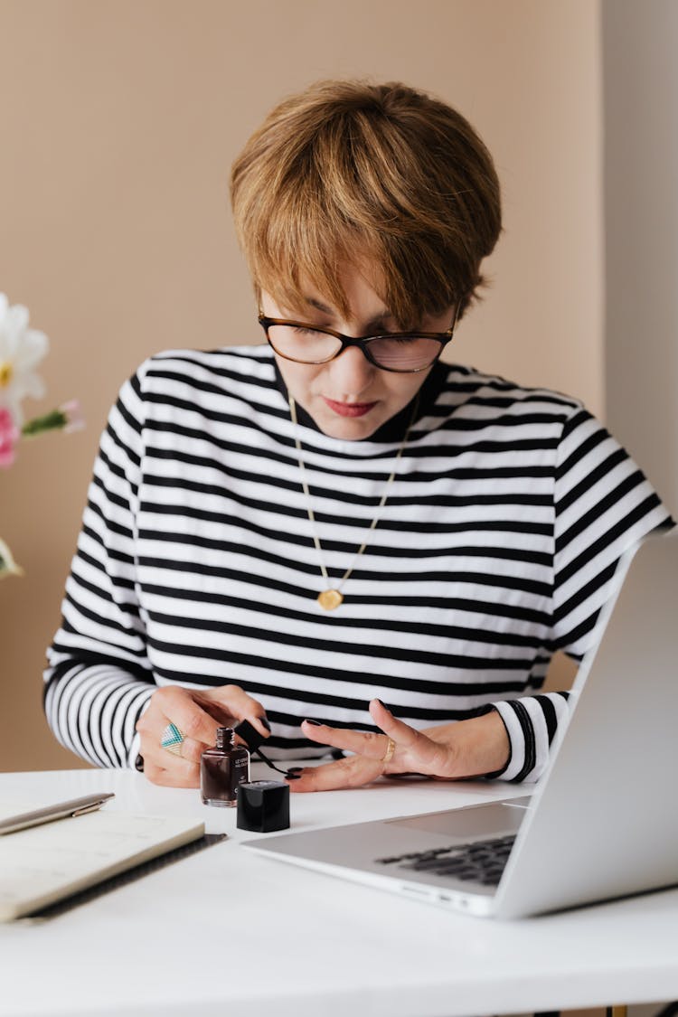 Focused Woman Doing Manicure With Black Nail Polish