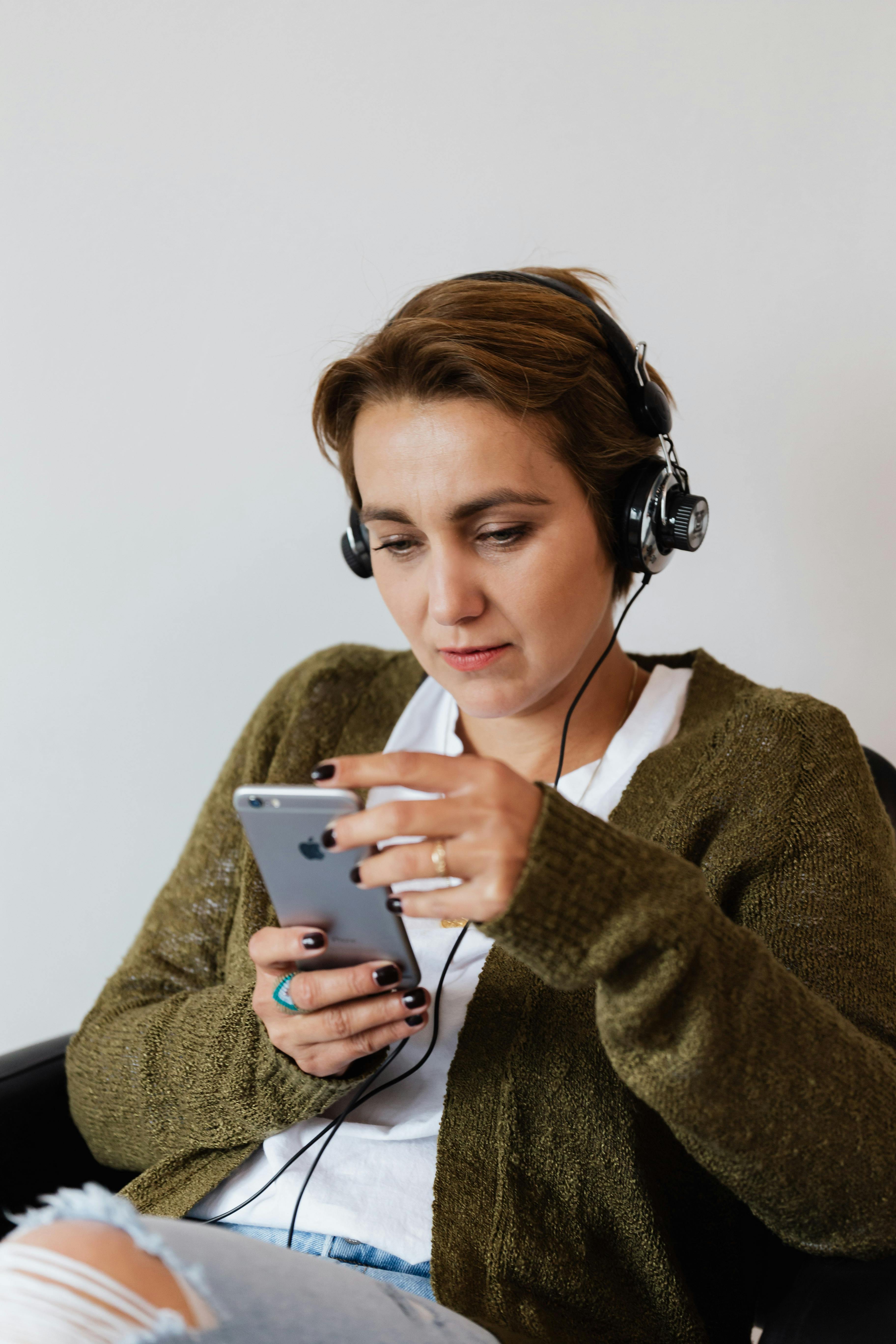 positive woman using smartphone and headphones