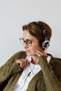 Glad woman in eyeglasses using headphones