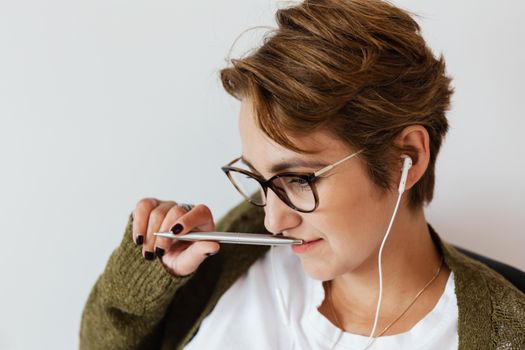 室内，一位戴眼镜的年轻女子听着音乐，若有所思