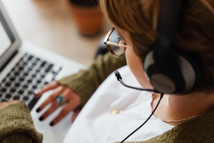 Woman Wearing Headphones Using Laptop