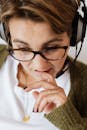 一个戴着耳机和眼镜的女人在室内陷入沉思的特写