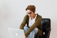 自信的女性在家使用笔记本电脑，展现了现代远程工作的生活方式
