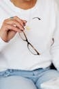 Crop anonymous woman with eyeglasses in hand