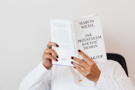Faceless woman immersed in reading book