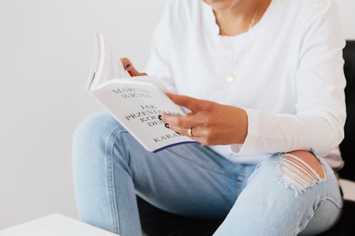 Free Faceless woman in casual clothes reading book Stock Photo
