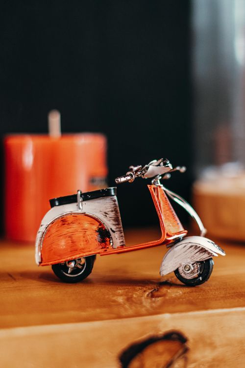 Free Toy mockup of retro motor scooter placed on shelf near candle at home Stock Photo