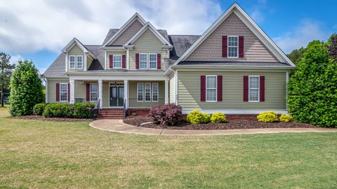 Beautiful two-story suburban house with manicured lawn and front porch.