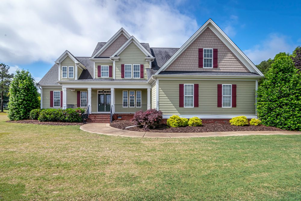 High-end detached American suburban home with attractive landscaping, exterior only