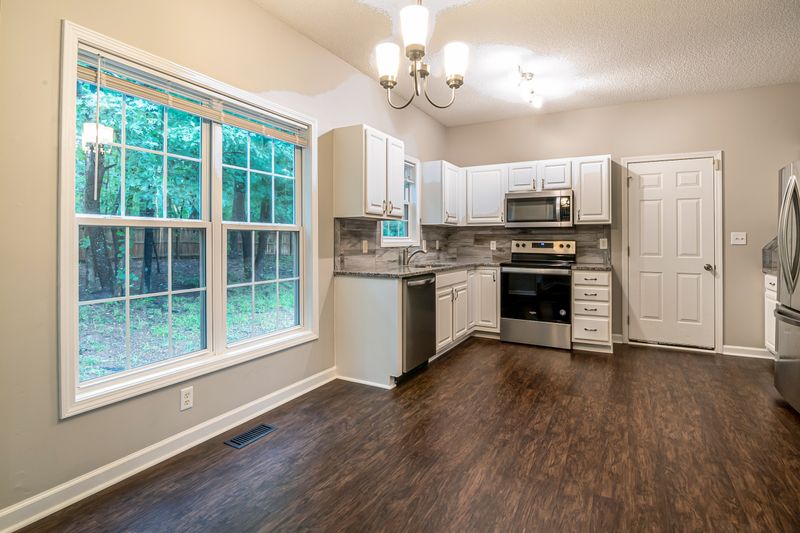 Spacious kitchen featuring modern appliances, large windows, and stylish cabinetry.