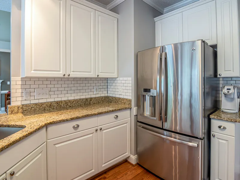 Bright modern kitchen with granite counters, steel appliances and white cabinets Bright modern kitchen with granite counters, steel appliances and white cabinets