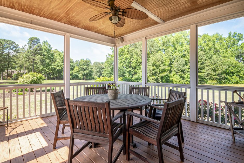 Large outdoor patio showing sturdy wooden furniture and lush garden views, emphasizing natural material choices and spacious comfort.