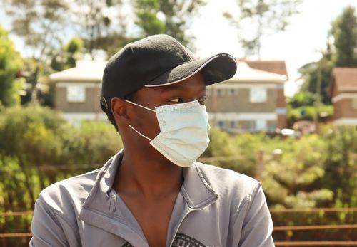 Free Portrait of a man in a mask and cap in Nyeri, Kenya, outdoors during summer. Stock Photo