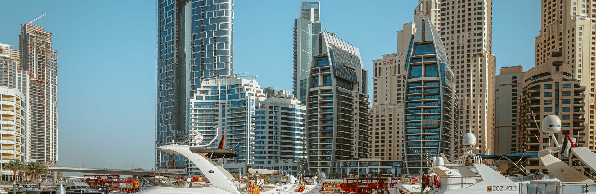 Stunning view of luxury yachts docked in Dubai Marina with the modern skyscrapers in the background.