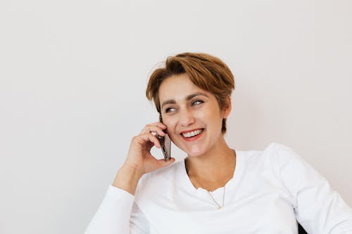 Happy woman speaking on smartphone and smiling