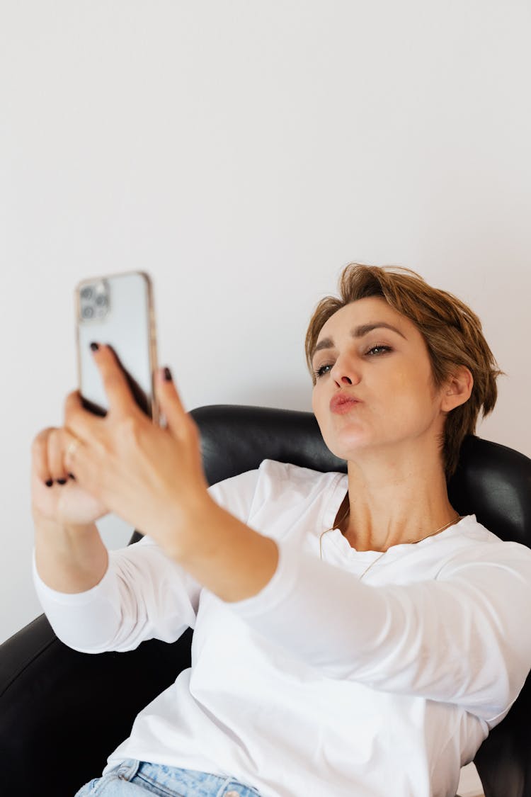 Woman Taking Selfie On Smartphone Pouting Lips