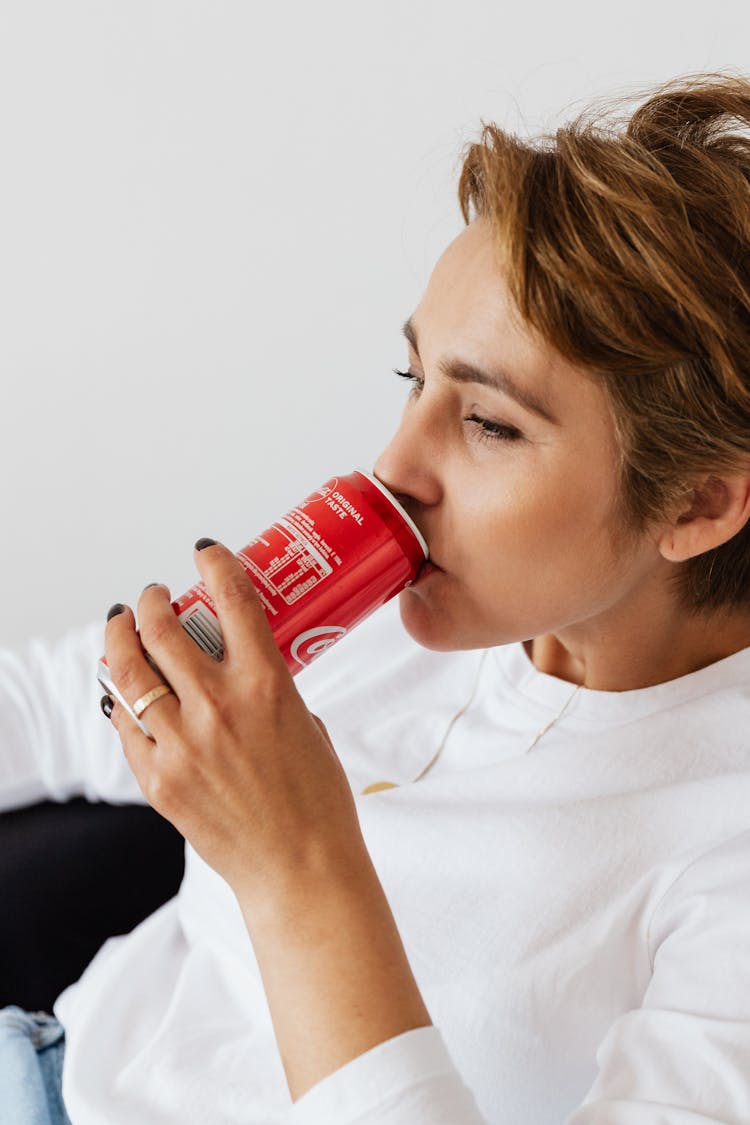 Crop Thirsty Female Drinking Coke On White Background