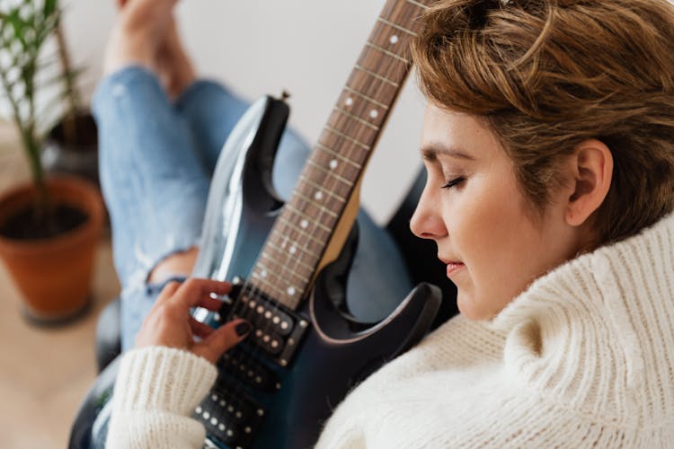 Crop Woman Playing Electric Guitar With Pleasure