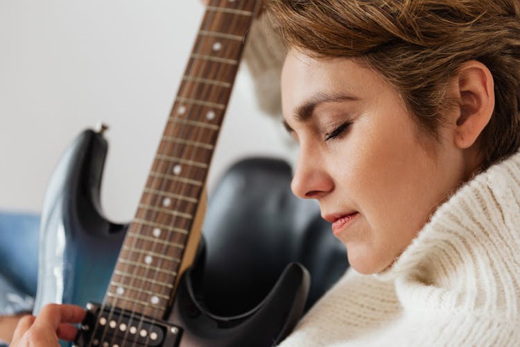 Calm Woman Playing Electric Guitar With Closed Eyes