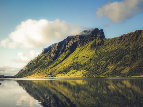 Serene landscape of mountains and reflection in a calm lake in Nordland, Norway.