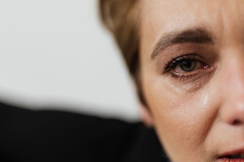 Free A close-up of a woman's eye with visible emotions and tears, capturing human expressions vividly. Stock Photo